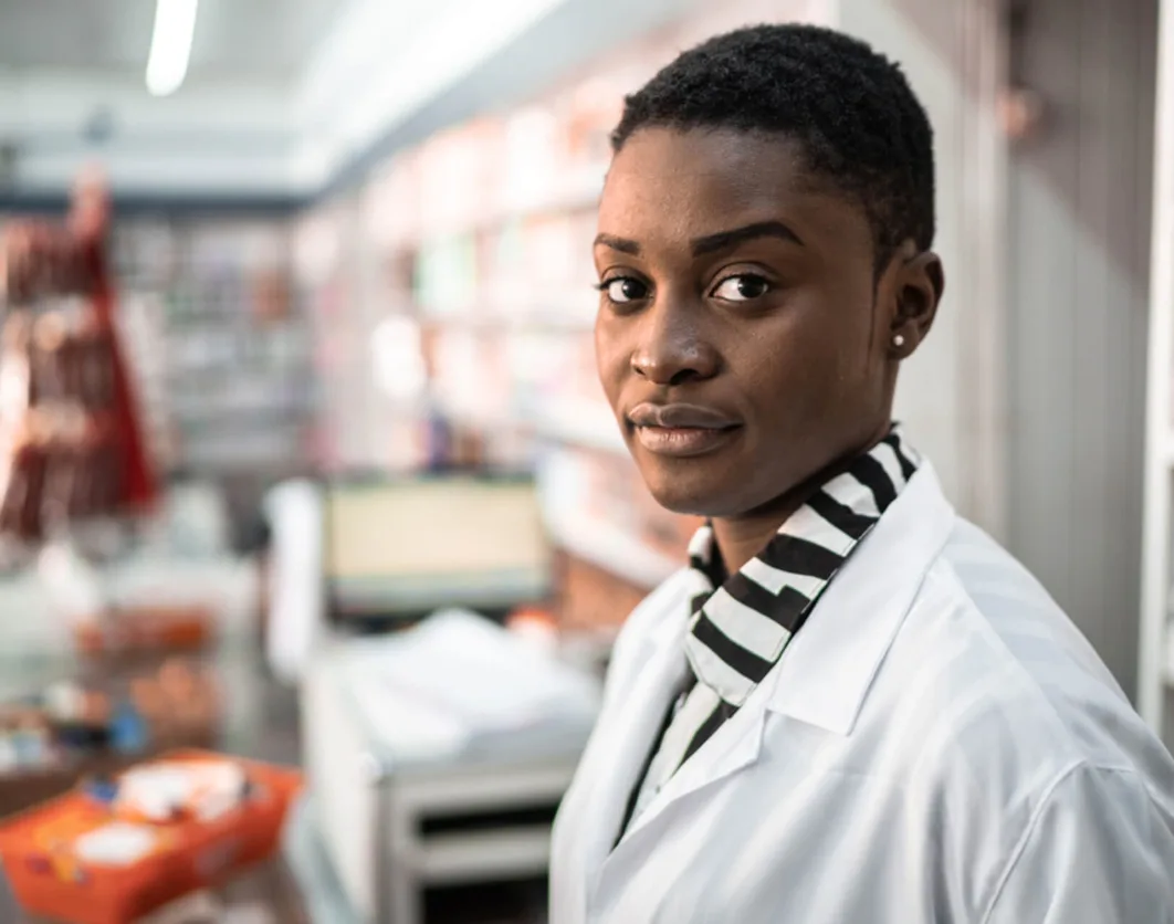 Pharmacist standing in a well-stocked pharmacy